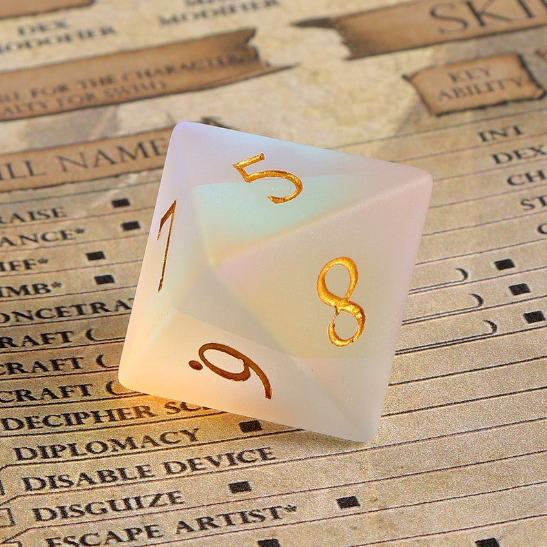 May include: A frosted, iridescent D20 die with gold-colored numerals. The die is set against a backdrop of a role-playing game character sheet. The numbers 1, 5, 8, and 9 are visible.
