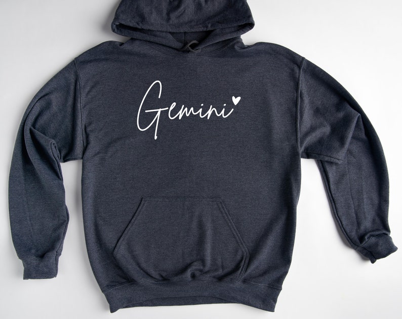 May include: A dark gray hooded sweatshirt with the word "Gemini" written in white cursive with a small white heart next to it.