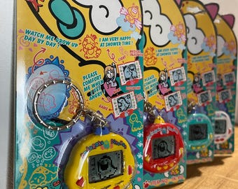 Tamgotchi - Dinkie Dino - Rakuraku Dinokun | NIEUW!!! Groen, geel, wit, rood