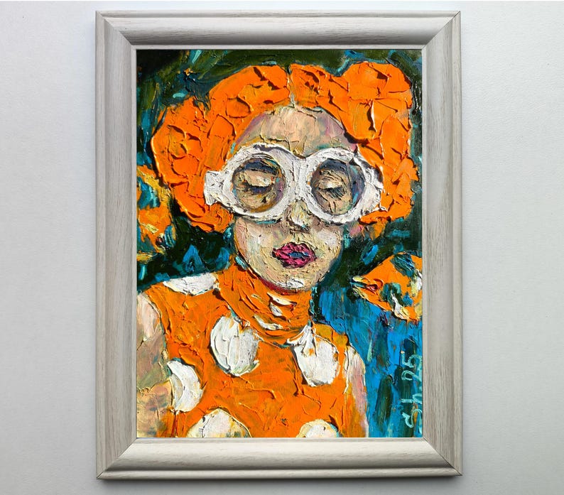 Pode incluir: Retrato em pintura a &oacute;leo de uma pessoa com cabelo laranja e &oacute;culos com arma&ccedil;&atilde;o branca. A pessoa est&aacute; vestindo uma blusa laranja com bolinhas brancas. A obra de arte &eacute; emoldurada em uma moldura prateada.