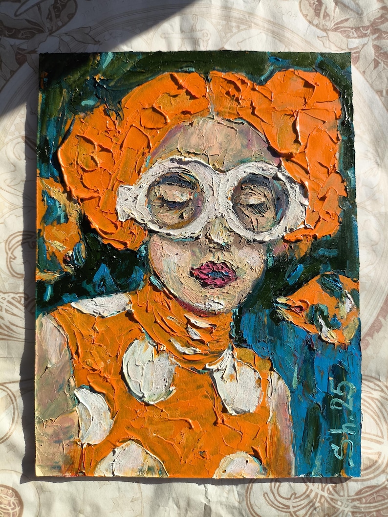 Pode incluir: Pintura a &oacute;leo de uma pessoa com cabelo laranja e &oacute;culos de arma&ccedil;&atilde;o branca. A pessoa est&aacute; vestindo uma blusa laranja com bolinhas brancas. O fundo &eacute; uma mistura de azul e verde. A pintura &eacute; assinada "Sh 25".