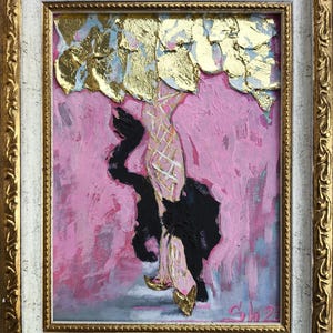 May include: Abstract painting in a gold and white ornate frame. The artwork features a figure with a pink background, gold leaf accents, and black accents. The figure is wearing gold shoes.