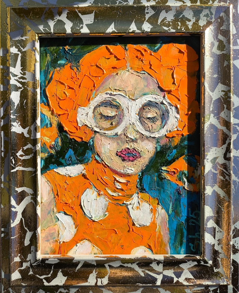 Pode incluir: Pintura a &oacute;leo de uma pessoa com cabelo laranja e &oacute;culos de arma&ccedil;&atilde;o branca. A pessoa usa um top laranja com bolinhas brancas. A pintura est&aacute; em uma moldura dourada e prateada ornamentada. O fundo &eacute; azul e verde.