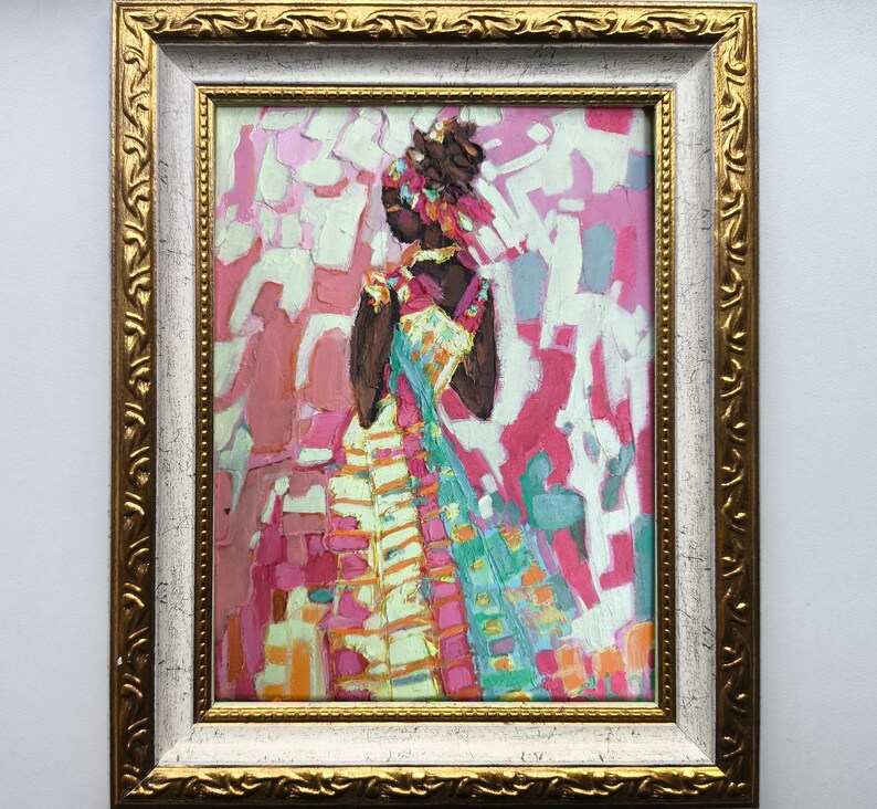 Pode incluir: Pintura a &oacute;leo em uma moldura dourada e branca ornamentada. A obra retrata uma figura em um vestido colorido com um fundo rosa e branco. A figura &eacute; de pele escura e usa um adorno de cabe&ccedil;a. A pintura tem um estilo texturizado e impressionista.