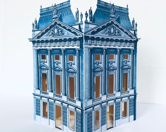 May include: A blue and white paper model of a building with intricate details and multiple windows. The model is made of cardstock and is assembled in a 3D format.