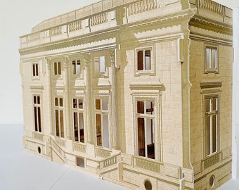 Puede incluir: Un modelo de papel beige de un edificio clásico con múltiples ventanas y una fachada detallada. El modelo está hecho de papel y tiene una superficie texturizada.