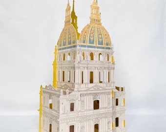 May include: A paper model of a church with two towers and a dome. The model is made of white paper with gold accents and blue details. The church is a detailed representation of a traditional European church.
