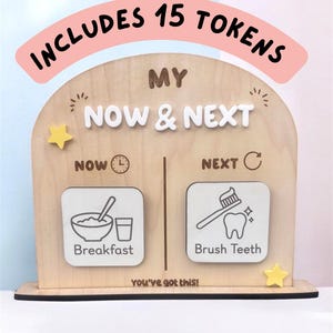 May include: A light-coloured wooden arch-shaped visual schedule board with the text "INCLUDES 15 TOKENS" at the top. The board features "MY NOW & NEXT" text, with two square slots labelled "NOW" and "NEXT" containing icons for breakfast and brushing teeth.
