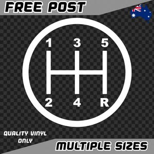 May include: White vinyl decal of a car's manual transmission gear shift pattern, with numbers 1 to 5 and R for reverse, within a circular frame. Text at the top reads "FREE POST", and at the bottom "QUALITY VINYL ONLY" and "MULTIPLE SIZES".