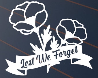 May include: White poppy flower cut-out design with the words "Lest We Forget" on a banner. The image features two detailed poppy flowers with leaves and stems. The background is a dark blue with brown diagonal lines.