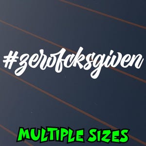 May include: A white vinyl decal featuring the hashtag text #zerofcksgiven in a cursive script font. Below the main decal, the text MULTIPLE SIZES is displayed in a bold, green, jagged-edged font against a dark background.