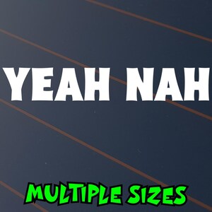May include: A dark blue background with the white text "YEAH NAH" in a bold font. Below, in green text, it says "MULTIPLE SIZES". Diagonal brown lines are visible in the background.
