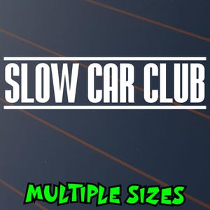 May include: A dark blue background with the white text "SLOW CAR CLUB" in a bold, sans-serif font, framed by white lines. Below, the words "MULTIPLE SIZES" are in green, stylized text.