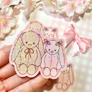 Autocollant découpé holographique en forme de deux peluches | Sticker individuel holographique en vinyle Lapin doudou timide Sticker kawaii pour ordinateur portable rose beige