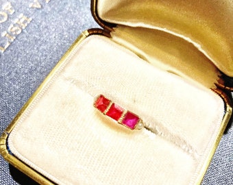 Ruby ring flanked by a seed pearl on both sides, set in 14K rose gold.