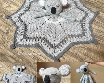 May include: A gray crocheted baby blanket with a gray crocheted koala attached. The blanket is shaped like a star and has a white border. The koala has black eyes and a black nose.