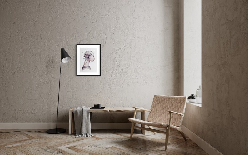 May include: A framed illustration of a person's profile with a detailed, spiky design on their head. The background is a light gray wall with a wooden floor.