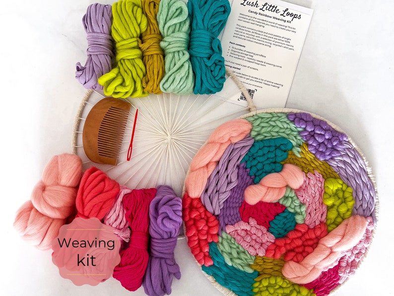 May include: A colorful yarn weaving kit with a wooden loom, comb, and yarn in shades of pink, purple, green, yellow, and blue. The kit includes instructions for creating a wall hanging. "Lush Little Loops" and "Candy Rainbow Weaving Kit" are printed on the instructions.
