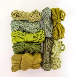 May include: An assortment of green yarn bundles in various shades, from light olive to deep forest green. The yarn textures vary, including smooth, textured, and fluffy, arranged on a white background. Ideal for crafting and textile projects.