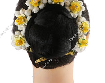May include: A set of six white and yellow flower hair clips. The clips are arranged in a circle around a black hair bun.