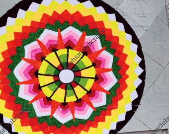 May include: A colorful mandala design with a black border. The mandala is made up of concentric circles of red, yellow, green, and white.