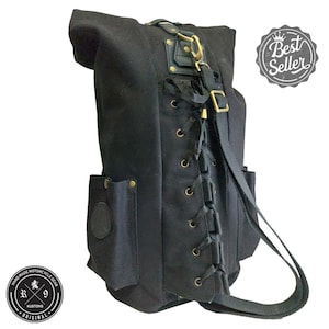 Könnte beinhalten: Schwarzer Canvas-Rucksack mit Schnürdetail auf der Rückseite, einer großen Tasche an der Seite und einer kleinen Tasche vorne. Der Rucksack hat einen schwarzen Riemen und eine goldene Schnalle.