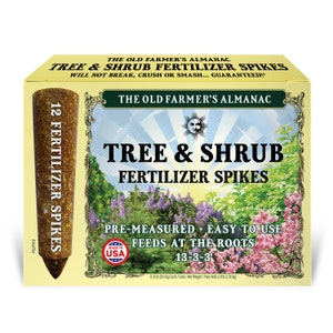 May include: A box of 12 tree and shrub fertilizer spikes. The box is yellow with a green border and features a sun and moon design. The spikes are brown and are labeled "13-3-3". The box also states "Pre-measured - Easy to Use - Feeds at the Roots" and "Made in USA".