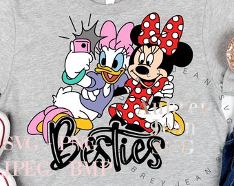 Op de afbeelding: Een grijs T-shirt met een afbeelding van Minnie Mouse en Daisy Duck die een selfie maken. De tekst "Bestie" staat onder de afbeelding.
