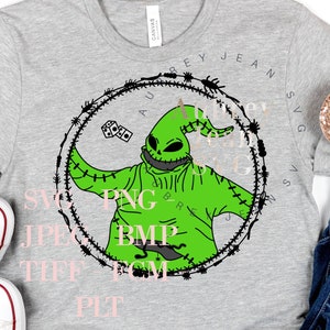 Puede incluir: Una camiseta gris con un personaje verde con puntadas y un círculo negro a su alrededor. El personaje sostiene un dado y lleva un sombrero negro con un cuerno verde. El texto alrededor del personaje dice "SVG PNG JPG TIF BMP  EPS  PDF  PIT".