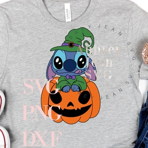 Pode incluir: Uma t-shirt cinzenta mesclada com um gráfico de um personagem alienígena azul a usar um chapéu de bruxa verde e sentado numa abóbora laranja. A peça é exibida com ténis brancos e calças de ganga azuis com uma bandolete de lantejoulas.