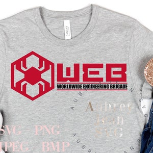 May include: A gray t-shirt with a red hexagonal logo that says "WEB WORLDWIDE ENGINEERING BRIGADE" in white text. The shirt is laying on a white surface with a pair of white sneakers, a pair of blue jeans, and a gold headband with a pink bow.
