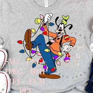 May include: A gray t-shirt with a cartoon image of Goofy tangled in Christmas lights. The image is in a colorful cartoon style. The t-shirt is on a white background with a pair of white sneakers and a pair of blue jeans with a gold glitter headband.