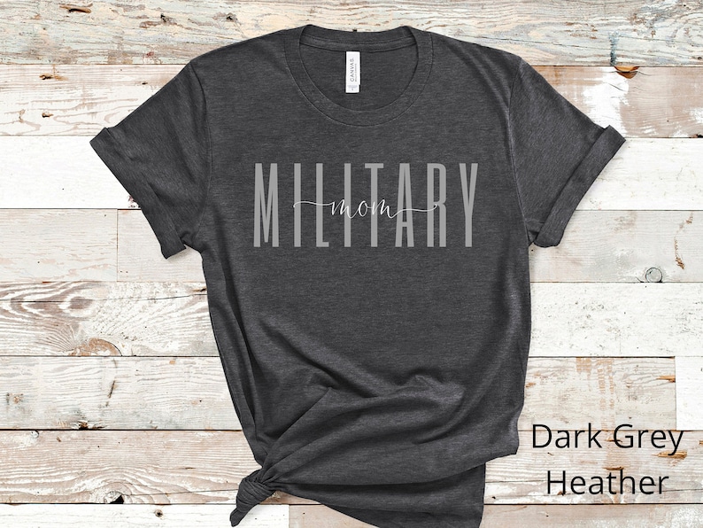 Pode incluir: Camiseta cinza escuro heather com o texto "MILITARY mom" em letras brancas.