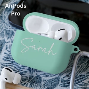 May include: A mint green Airpods Pro case with the name "Sarah" written in white on the front. The case is open and the Airpods are inside.