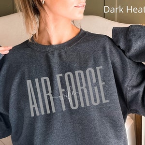 May include: Dark heather grey sweatshirt with the text "Air Force Wife" in white.