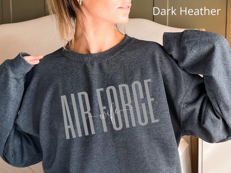 May include: Dark heather grey sweatshirt with the text "Air Force Wife" in white.