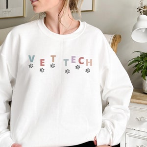 May include: White sweatshirt with the text "VET TECH" in rainbow colors with paw prints underneath each letter.