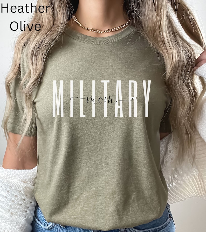 Pode incluir: Uma camiseta verde oliva com o texto "MILITARY mom" impresso em branco.