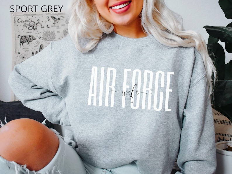 May include: A gray sweatshirt with the text "AIR FORCE wife" in white lettering.