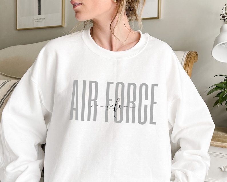 May include: White sweatshirt with the text "AIR FORCE wife" in gray letters.