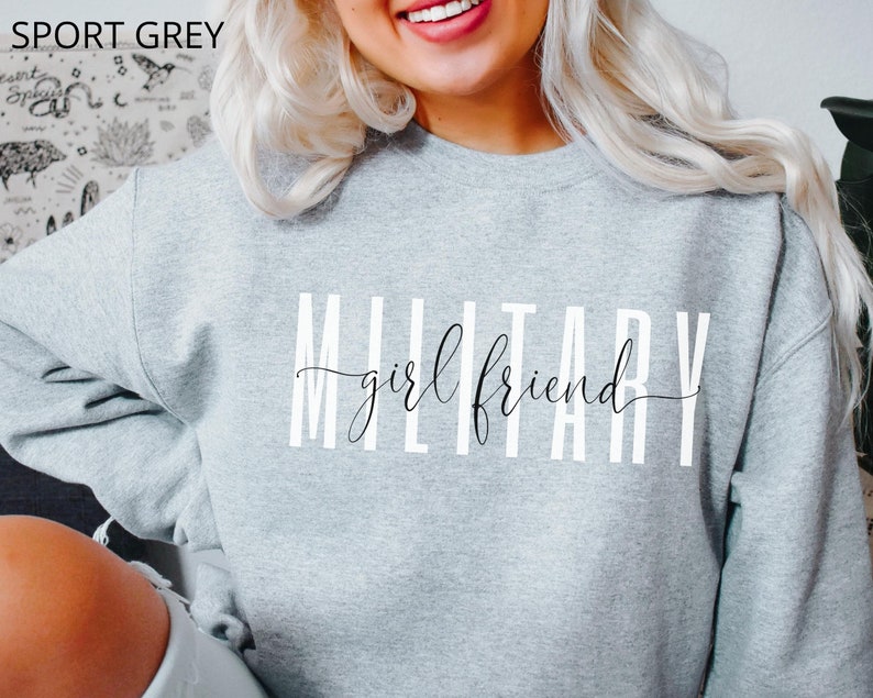 K&ouml;nnte beinhalten: Ein graues Sweatshirt mit dem Aufdruck "MILITARY girlfriend" in Wei&szlig;.