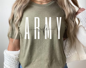 Puede incluir: Una camiseta verde con el texto "ARMY wife" en letras blancas.