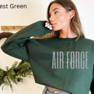 May include: Forest green cropped sweatshirt with the text "AIR FORCE wife" in gray lettering.