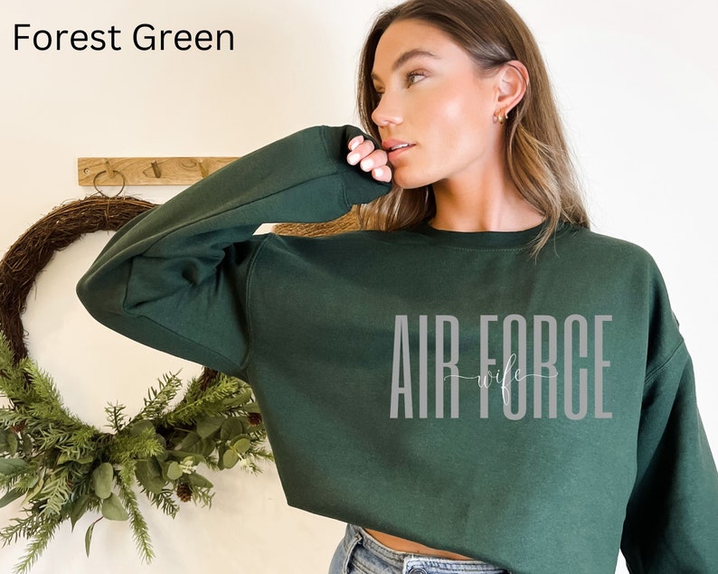 May include: Forest green cropped sweatshirt with the text "AIR FORCE wife" in gray lettering.