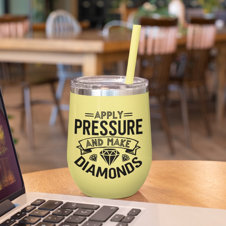 Peut inclure: Un gobelet &agrave; vin en acier inoxydable jaune avec une inscription noire qui dit "Appliquer la pression et faire des diamants".