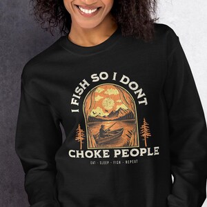 May include: Black sweatshirt with a graphic print of a person fishing in a lake with the text "I fish so I don't choke people Eat. Sleep. Fish. Repeat."