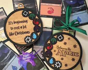 May include: Two wooden Christmas ornaments with black borders and green ribbon. One ornament says "It's beginning to cost a lot like Christmas." The other says "Believe in the Magic." Both have game symbols.