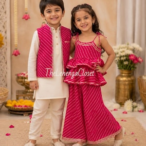 May include: A child wears a cream-colored kurta and pants with a magenta striped vest. Another child wears a magenta striped peplum top with thin straps and matching wide-leg pants. Both outfits feature gold trim. The text TheLehengaCloset is visible.