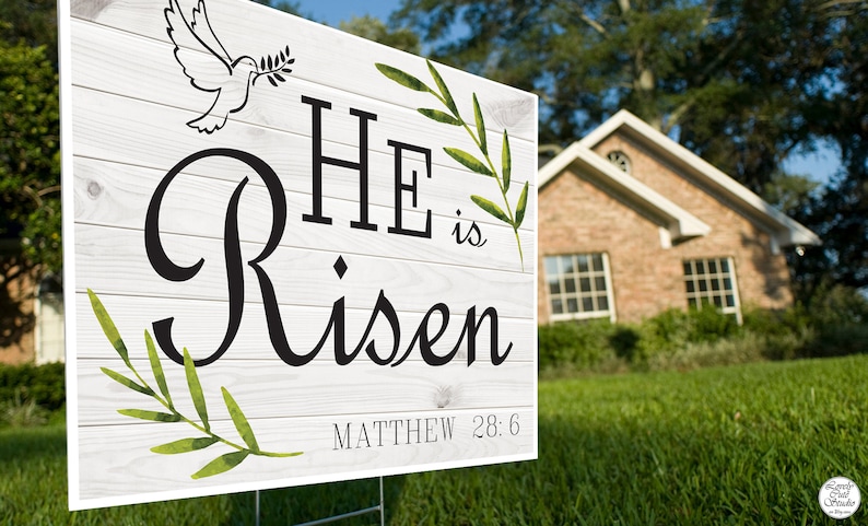 K&ouml;nnte beinhalten: Ein wei&szlig;es Holzschild mit gr&uuml;nen Bl&auml;ttern und einer Taube mit einem Olivenzweig. Das Schild tr&auml;gt die Aufschrift "HE is Risen" mit dem Bibelvers "MATTHEW 28:6".