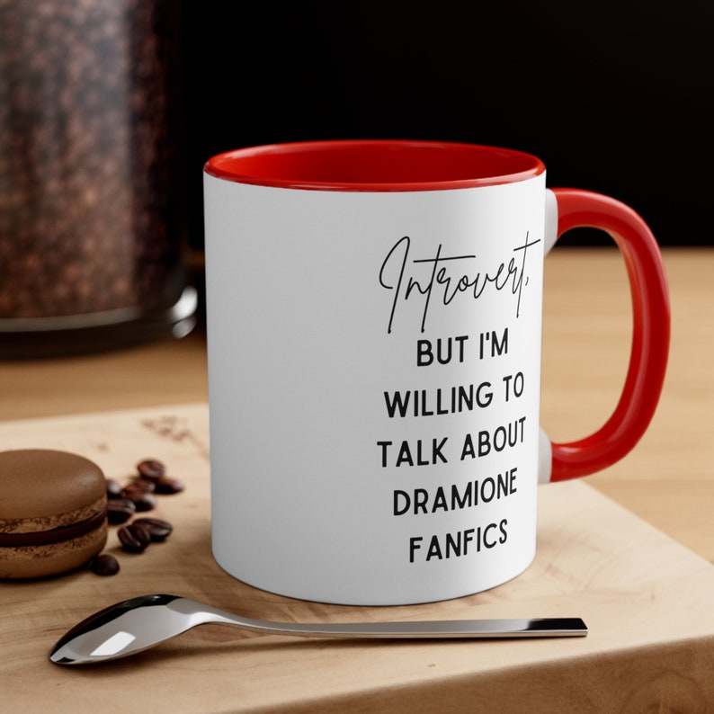 Puede incluir: Taza de cer&aacute;mica blanca con borde y asa rojos. La taza tiene texto negro que dice "Introvertido. Pero estoy dispuesto a hablar sobre Fanfics de Dramione."